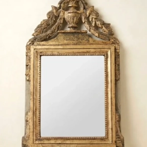 A Louis XVI gilded wood mirror with urn, flowers and garlands. Later plate. 18th century.