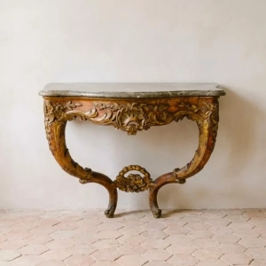 An exquisite and rare Louis XV period console. Gilded and lacquered with open shell, acanthus, flowers and trophy decoration.