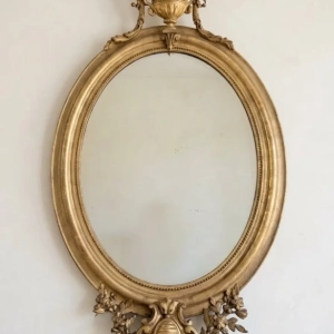 A stunning Louis XVI style oval mirror. Gilded wood. Late 19th century.