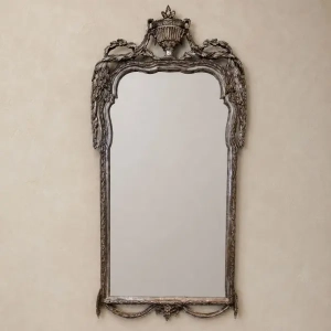 A delicately carved, Louis XVI style, silvered mirror. Decorated with an urn, rams head and garlands. French 19th century.