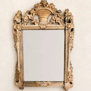 A Louis XVI gilded and painted wood mirror with a basket, flowers and leaves