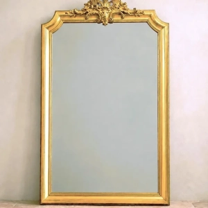 A large and very decorative gilded mirror. Original mirror speckled with desilvering spots that don't detract from the mirror.