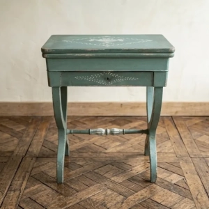 An attractive games table in blue painted wood. Decorated with a cup of grapes and garlands of leaves and flowers
