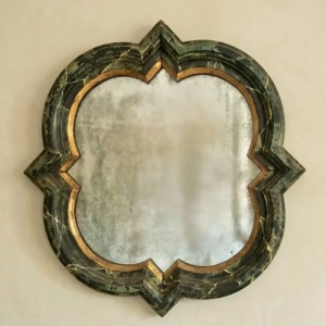 A unique, barbed quatrefoil shaped mirror. Distressed mirror plate with a faux marble and gilt frame