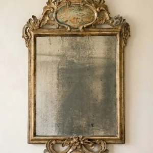 A charming and decorative gilt wood mirror. Featuring Oriental figures, a dragon and flying insects in the lacca povera technique. Original glass plate. Marche, 18th century.