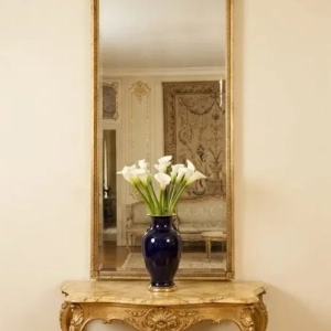A large pier mirror, exceptionally decorated with a cherub, scrolls and garlands. France, early 19th century.