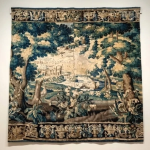 A charming tapestry, featuring a chateau, foliage and birdlife. Elaborate boarder to top and bottom. The tapestry has been backed, has historic and new repairs and a seam through middle. France, late 17th, early 18th century.
