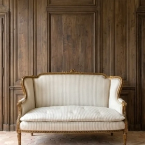 An attractive Louis XVI style, gilded canape/sofa upholstered in a ticking fabric. Early 20th century.