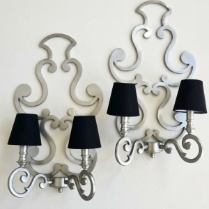 A decorative pair of metal, baroque style wall sconces.
