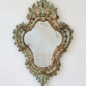 An exquisite Venetian mirror. Painted and mecca gilded wood. Original mercury glass plate with oxidation spots and marks. Italy, 18th century.