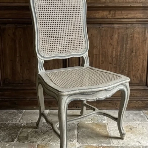 An attractively painted Louis XV style chair with cane back and seat.