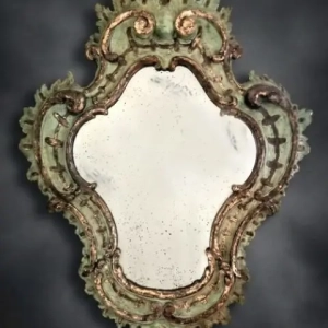 An exquisite Venetian mirror. Painted and mecca gilded wood. Original mercury glass plate with oxidation spots and marks. Italy, circa 1730.