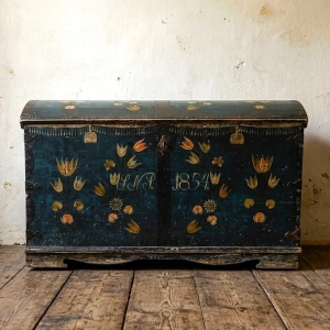 A charming, painted pine marriage or dowry trunk, featuring a dark blue finish with hand-painted floral motifs, initials, and the date. Sweden, 1854